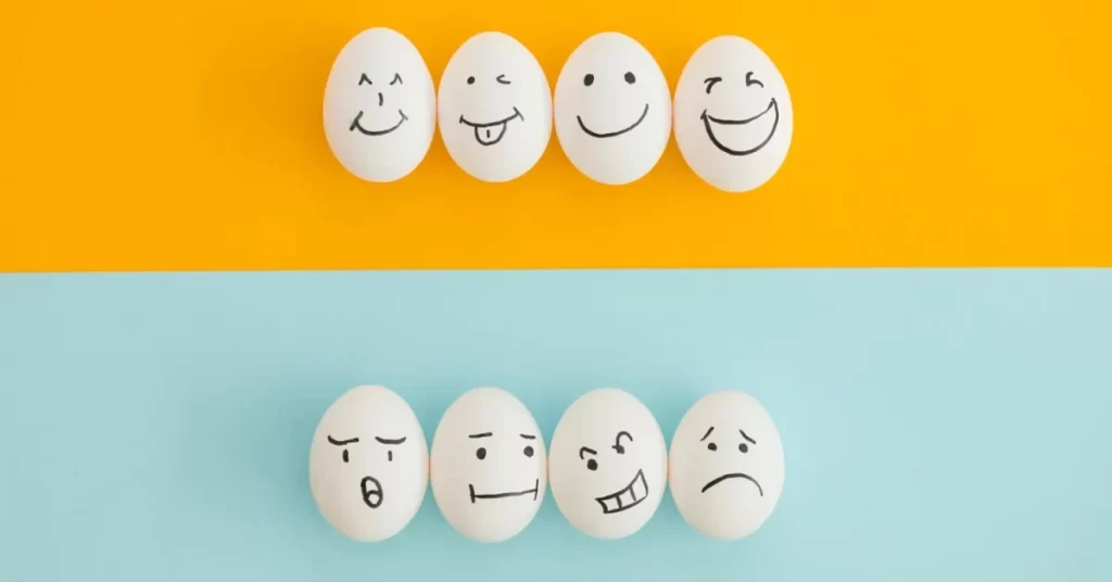 smiling sad eggs yellowblue background e1692737975100